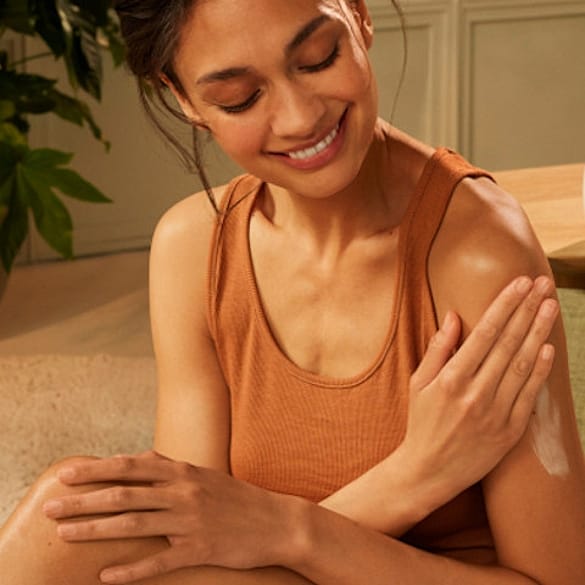Woman putting a lotion on her body